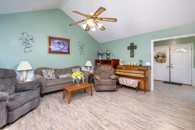 living room featuring vaulted ceiling, light hardwood / wood-style flooring, and ceiling fan