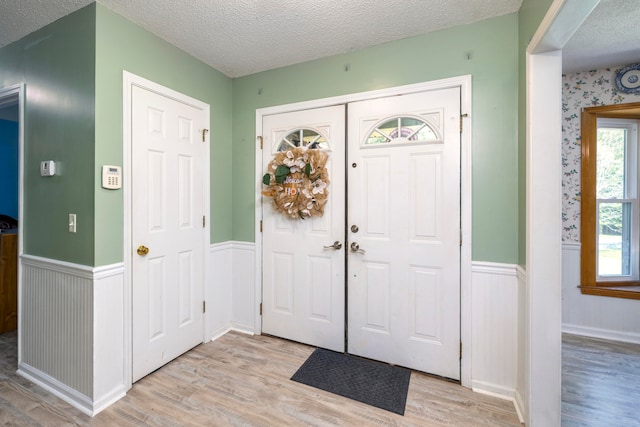 entrance foyer with a textured ceiling and light hardwood / wood-style flooring