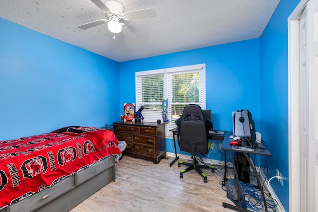 bedroom featuring a textured ceiling, ceiling fan, and light hardwood / wood-style floors