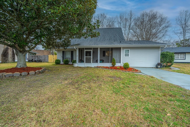 ranch-style house with covered porch, driveway, a front lawn, and fence