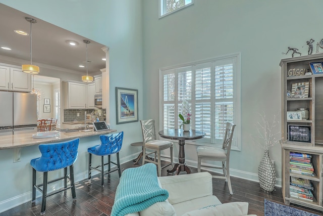 dining space with a wealth of natural light, dark wood-style flooring, and baseboards