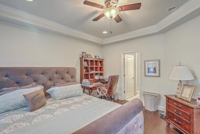 bedroom featuring recessed lighting, wood finished floors, baseboards, ornamental molding, and a tray ceiling