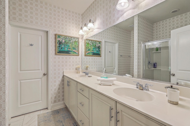 bathroom with wallpapered walls, a shower stall, and a sink