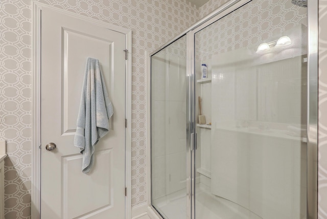 bathroom with wallpapered walls and a stall shower