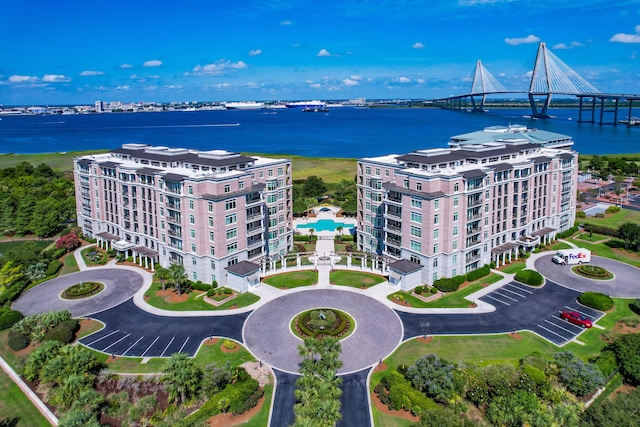 drone / aerial view of a nearby body of water and apartment complex / building