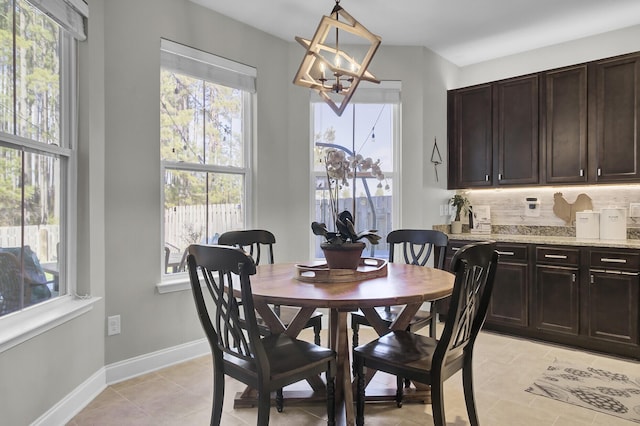 dining room with light tile patterned flooring and a chandelier