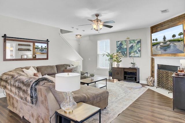 living room featuring dark wood-type flooring and ceiling fan