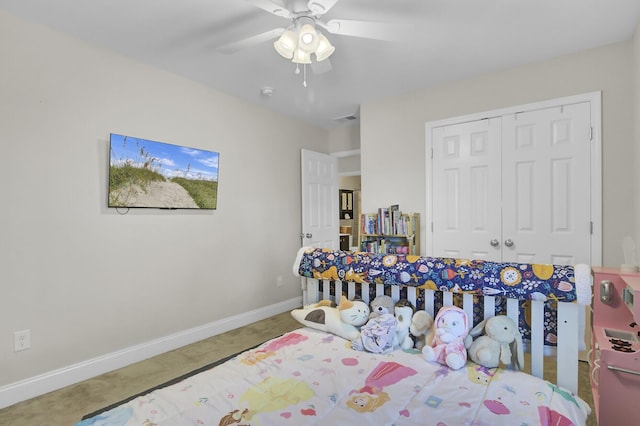 carpeted bedroom with ceiling fan and a closet