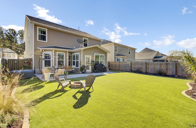 back of property featuring a lawn, a patio, and an outdoor fire pit