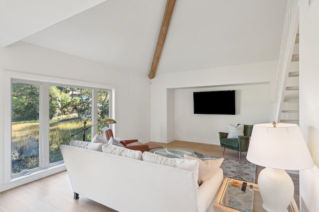 living room with lofted ceiling with beams and light hardwood / wood-style floors