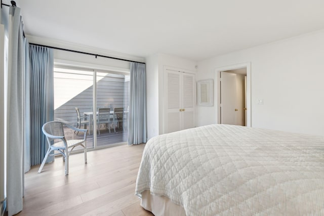 bedroom featuring access to exterior, light hardwood / wood-style flooring, and a closet