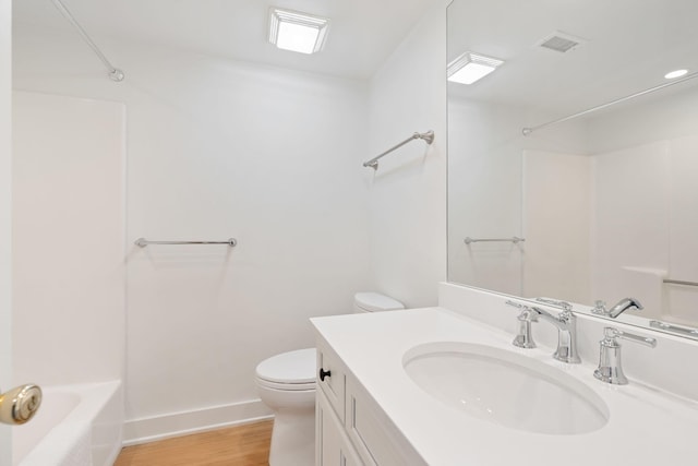 full bathroom featuring wood-type flooring, vanity, shower / bath combination, and toilet