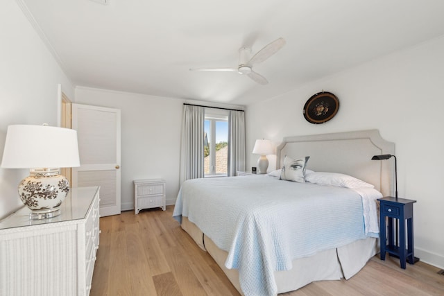 bedroom featuring light hardwood / wood-style flooring, ceiling fan, and ornamental molding