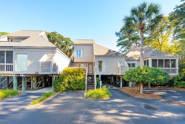 1505 Marsh Hvn, Johns Island, SC 29455 - view of front of house featuring a carport, stairs, a sunroom, roof with shingles, and driveway