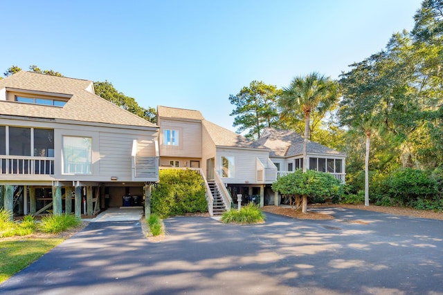 1505 Marsh Hvn, Johns Island, SC 29455 - view of front of property with asphalt driveway, a sunroom, stairway, a carport, and a shingled roof