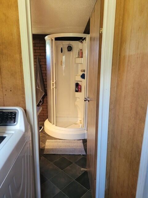 bathroom featuring washer / dryer and a shower