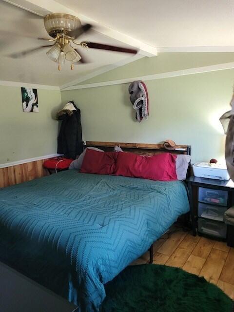 bedroom with vaulted ceiling with beams, wood-type flooring, ceiling fan, and crown molding