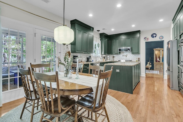 dining space featuring light wood-type flooring, recessed lighting, and baseboards
