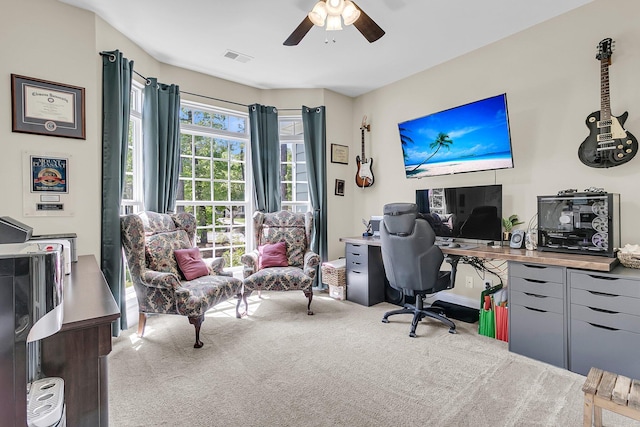 carpeted home office featuring ceiling fan