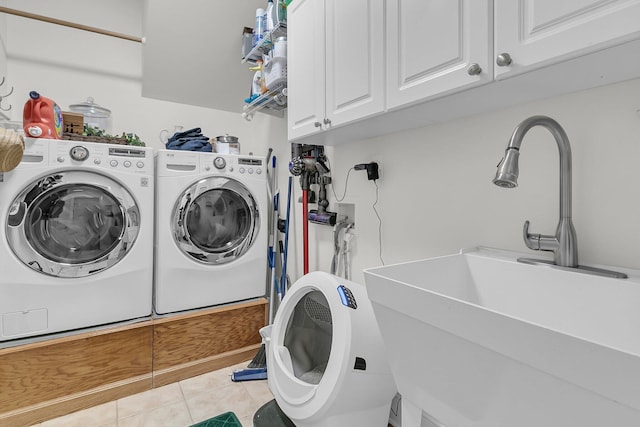 washroom featuring cabinet space, washer and clothes dryer, and tile patterned flooring