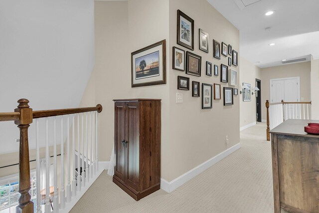 hallway with light colored carpet, an upstairs landing, baseboards, and recessed lighting