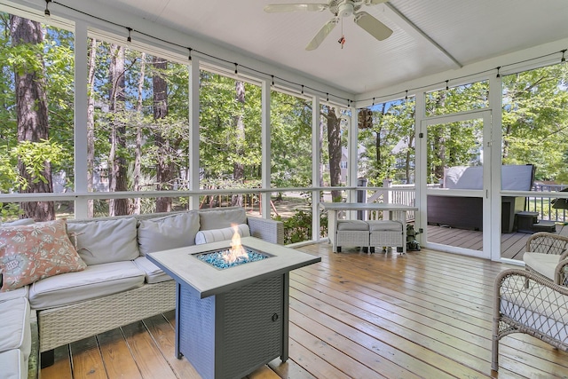 sunroom / solarium with an outdoor living space with a fire pit, ceiling fan, and plenty of natural light