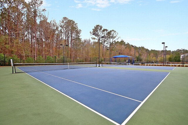 view of tennis court featuring fence and community basketball court