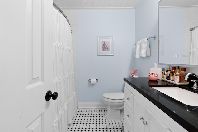 bathroom with baseboards, toilet, crown molding, vanity, and tile patterned flooring