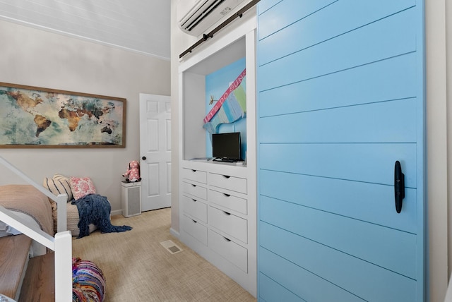 interior space featuring visible vents, baseboards, a barn door, light carpet, and a wall unit AC