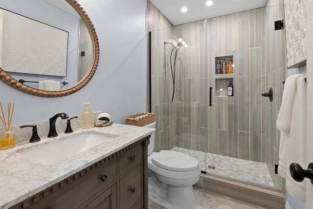 full bathroom featuring toilet, a stall shower, vanity, and recessed lighting