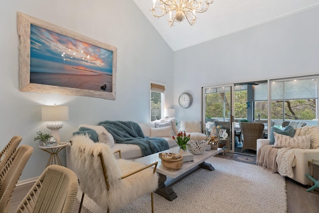 living room featuring high vaulted ceiling, a chandelier, and wood finished floors