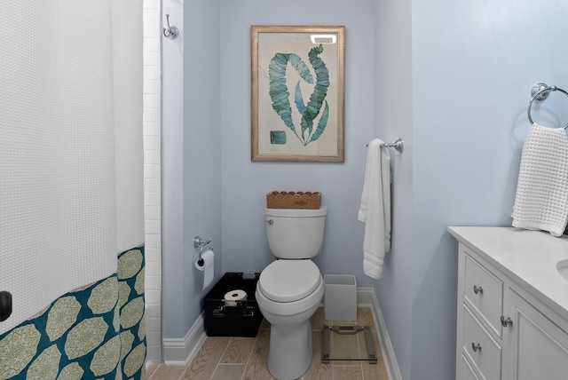 full bath featuring toilet, a shower with shower curtain, vanity, and baseboards