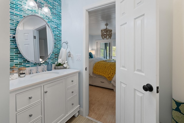 bathroom with decorative backsplash, connected bathroom, and vanity