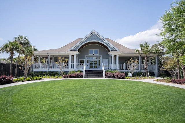 view of front of home featuring french doors, a front lawn, a shingled roof, and covered porch
