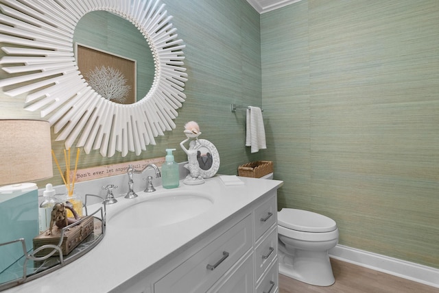 bathroom with toilet, vanity, and baseboards