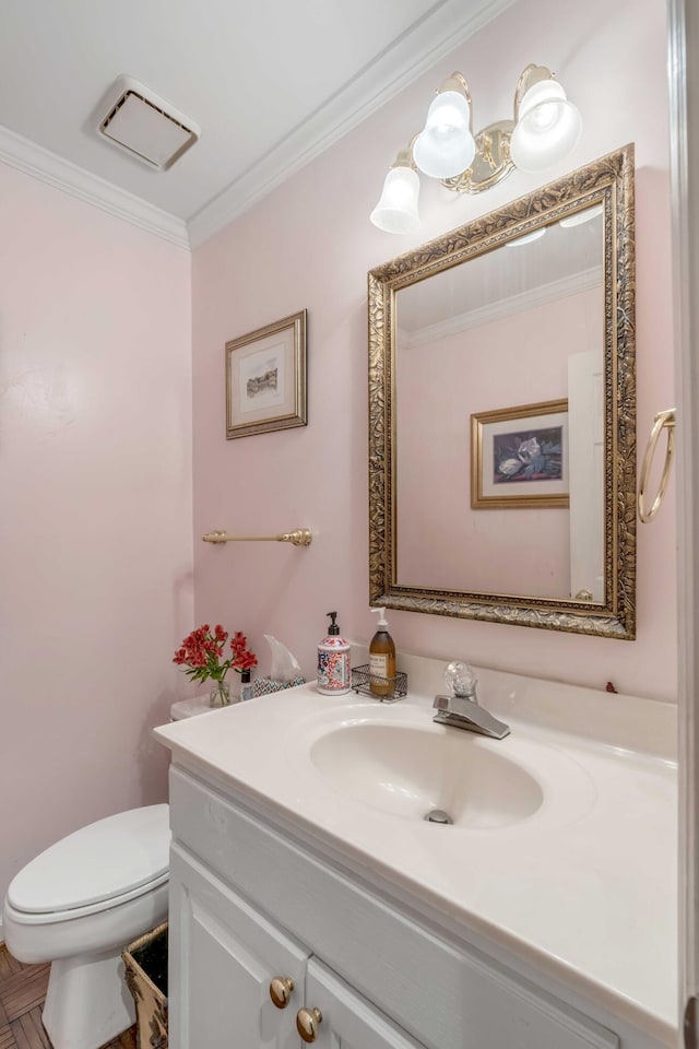 bathroom with parquet flooring, toilet, vanity, and ornamental molding