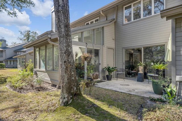 rear view of property with a patio area and a sunroom