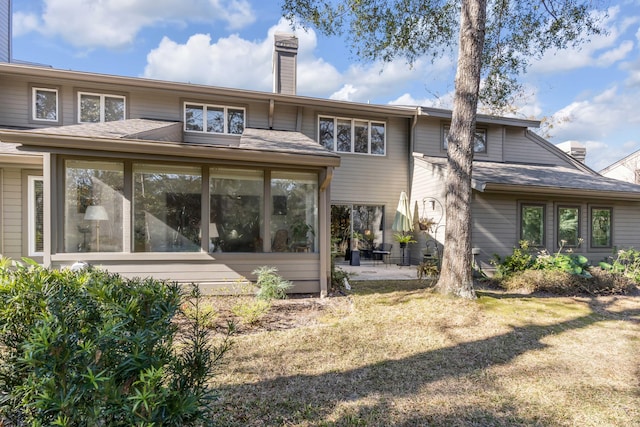 rear view of property featuring a sunroom