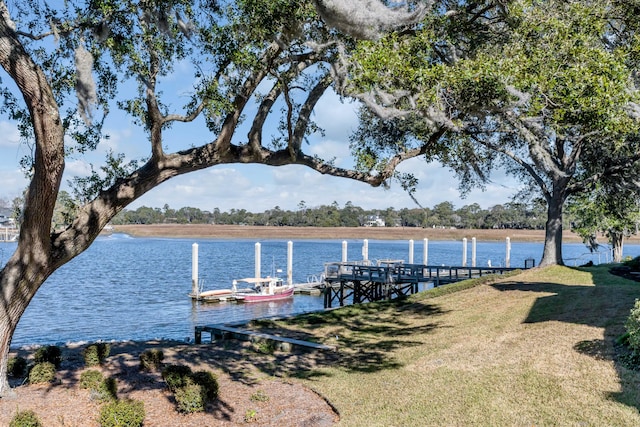 view of dock with a yard and a water view