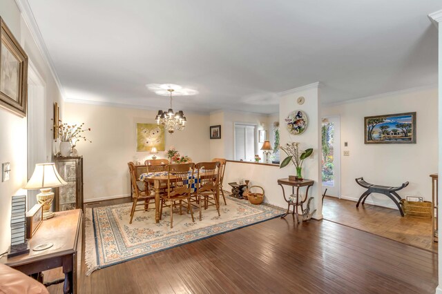 dining room featuring hardwood / wood-style flooring, an inviting chandelier, and crown molding