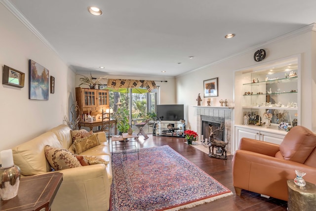 living room featuring a fireplace, crown molding, built in features, and dark wood-type flooring