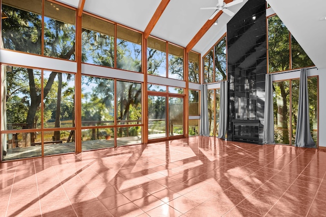 unfurnished sunroom featuring a tile fireplace, ceiling fan, and lofted ceiling