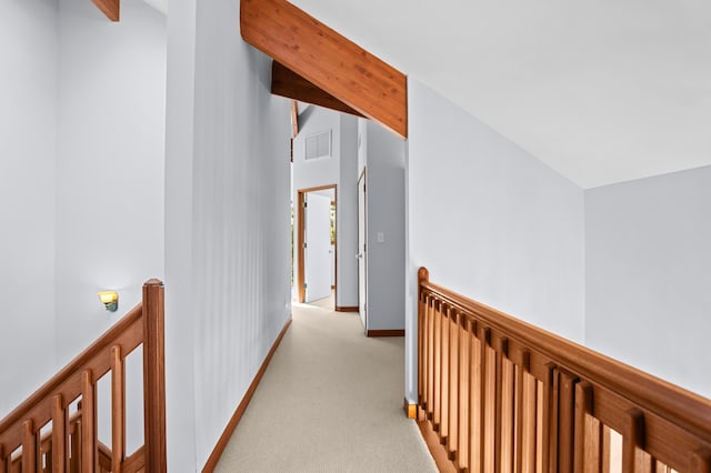 hallway featuring vaulted ceiling with beams and light colored carpet