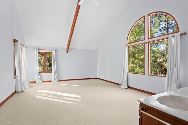 interior space featuring light colored carpet, high vaulted ceiling, ceiling fan, and sink