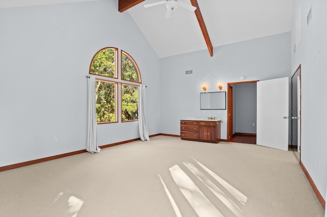 unfurnished bedroom with beamed ceiling, light colored carpet, high vaulted ceiling, and ceiling fan