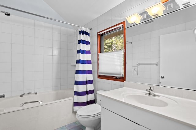 full bathroom with tile patterned floors, vanity, shower / bath combo with shower curtain, tile walls, and toilet