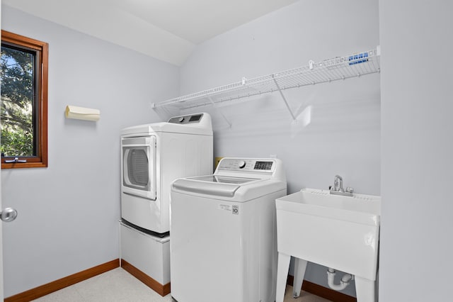 clothes washing area with washer and clothes dryer and sink