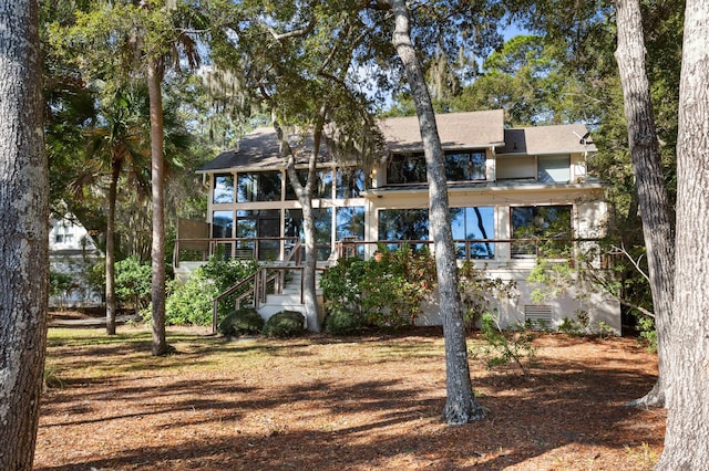 back of property with a sunroom