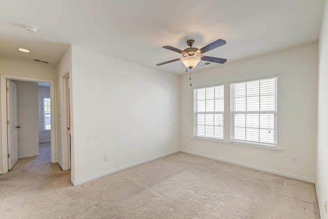 carpeted spare room featuring ceiling fan