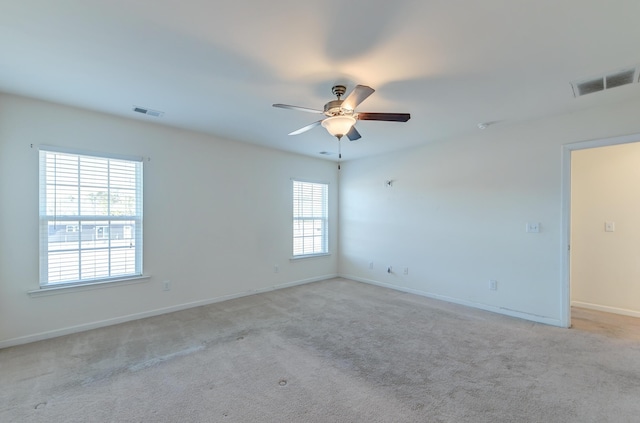 carpeted spare room featuring ceiling fan